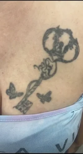 Altes Schlüssel-Tattoo mit Schmetterlingen vor dem Cover-Up